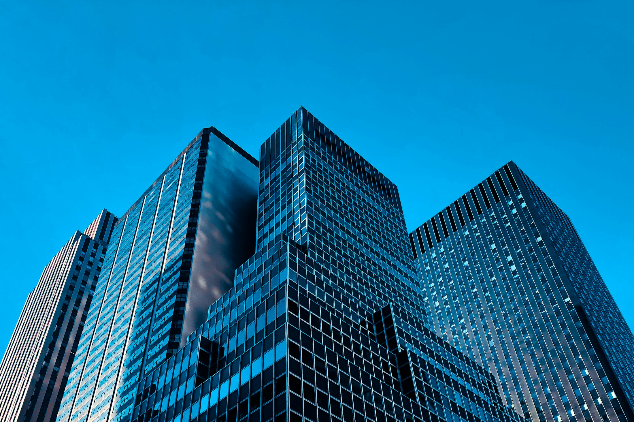 Dark glass office towers rising into a clear morning sky